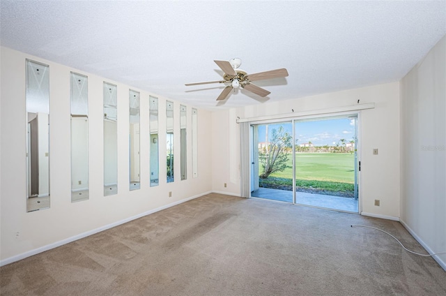 carpeted empty room with ceiling fan and a textured ceiling