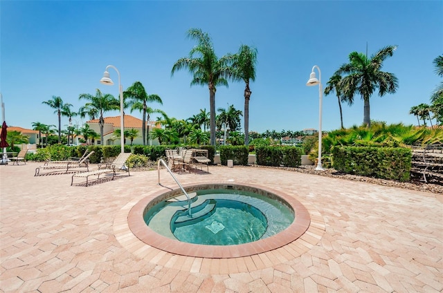 view of pool with a hot tub and a patio