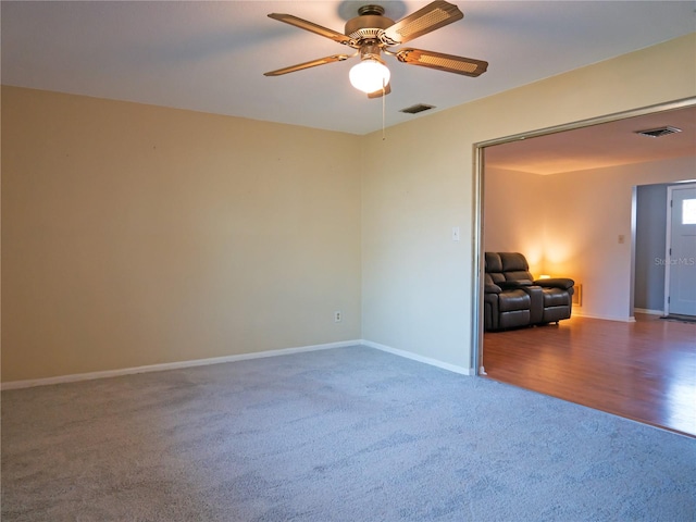 carpeted spare room with ceiling fan