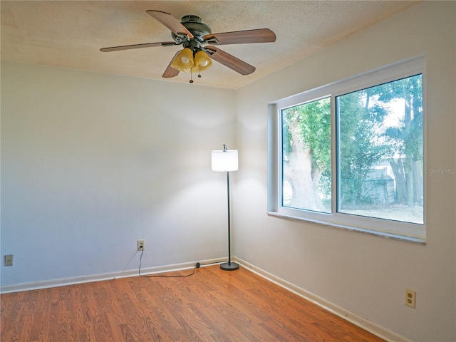 empty room featuring ceiling fan, hardwood / wood-style floors, and a textured ceiling