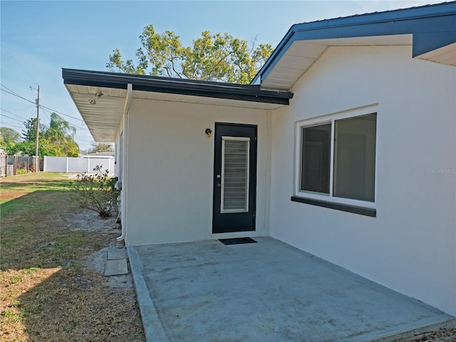 property entrance with a yard and a patio