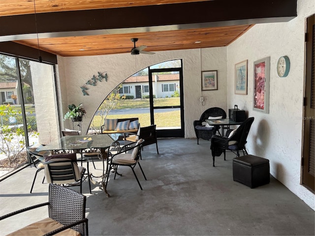 dining room featuring beam ceiling and concrete floors