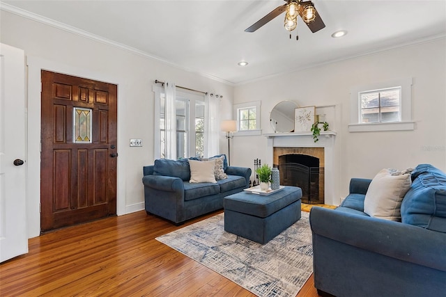 living room with wood-type flooring, ceiling fan, and crown molding