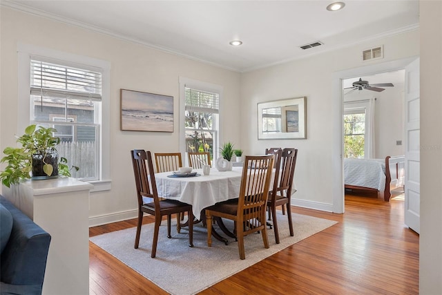 dining room featuring ornamental molding, plenty of natural light, and wood-type flooring