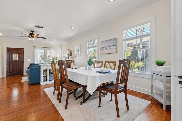 dining area featuring crown molding and hardwood / wood-style flooring