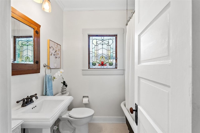 bathroom featuring ornamental molding, plenty of natural light, sink, and toilet