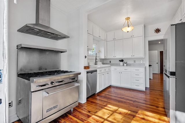 kitchen with wall chimney exhaust hood, sink, white cabinetry, hanging light fixtures, and appliances with stainless steel finishes