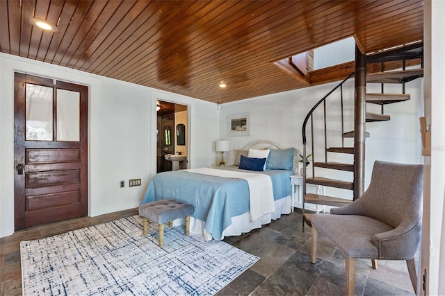 bedroom with connected bathroom, wood ceiling, and a skylight