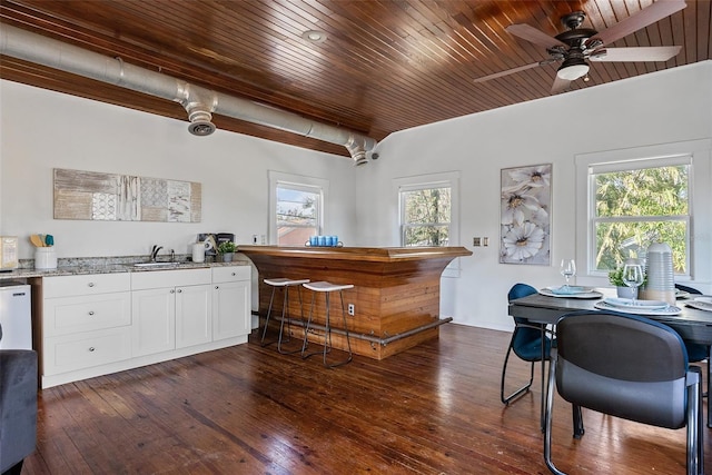 bar featuring sink, wood ceiling, dark wood-type flooring, white cabinetry, and light stone counters