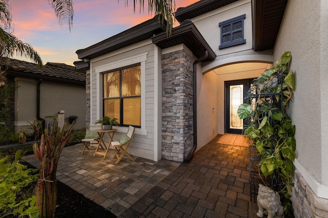 exterior entry at dusk with a patio area