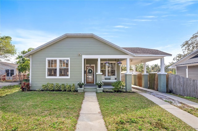 bungalow-style home featuring covered porch and a front lawn