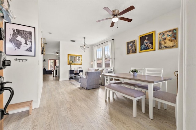 dining space with light hardwood / wood-style flooring and ceiling fan