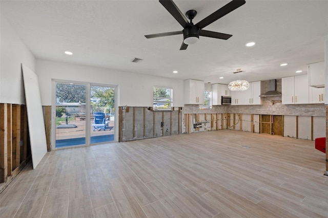 unfurnished living room with light hardwood / wood-style floors and ceiling fan