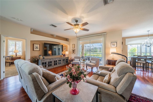 living room featuring plenty of natural light, dark hardwood / wood-style floors, and ceiling fan with notable chandelier