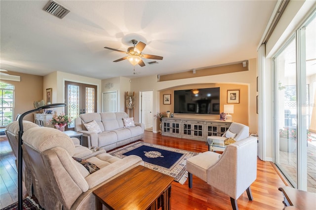 living room with hardwood / wood-style floors, ceiling fan, and french doors