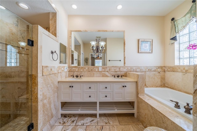 bathroom featuring vanity, separate shower and tub, tile walls, and a notable chandelier