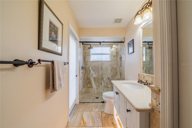 bathroom featuring toilet, vanity, and a shower with shower door