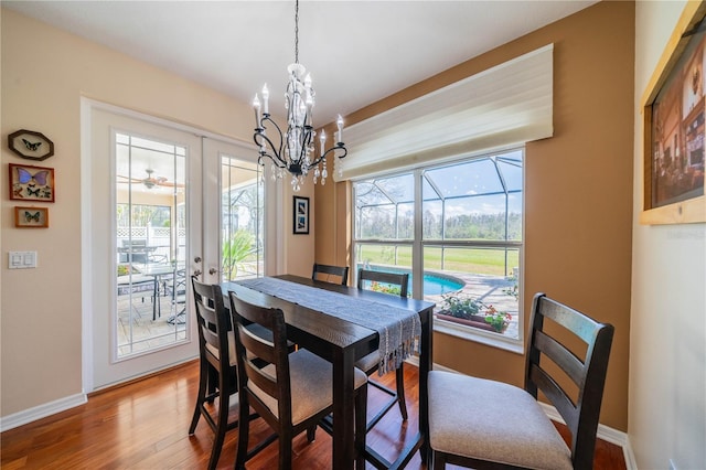 dining room featuring french doors, wood-type flooring, and an inviting chandelier