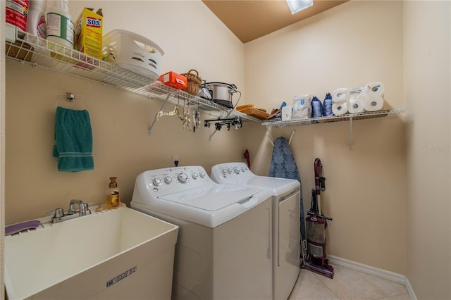 washroom with sink, washing machine and dryer, and light tile patterned floors