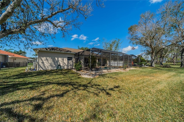 rear view of property featuring a lanai and a lawn