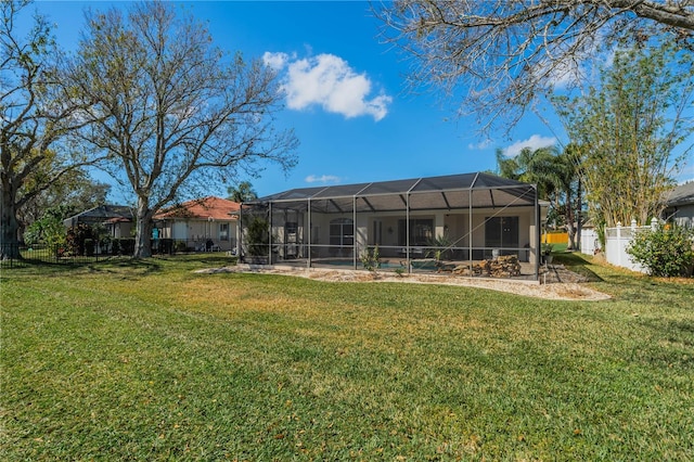 rear view of house featuring a lanai and a lawn