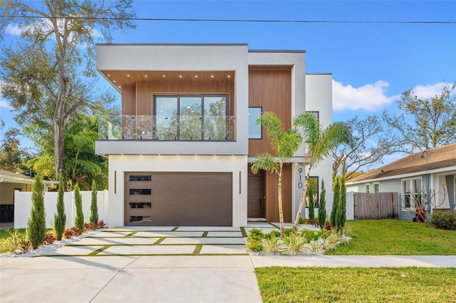 contemporary house with a garage, a balcony, and a front lawn