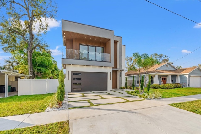 contemporary home with a garage, a front yard, and a balcony