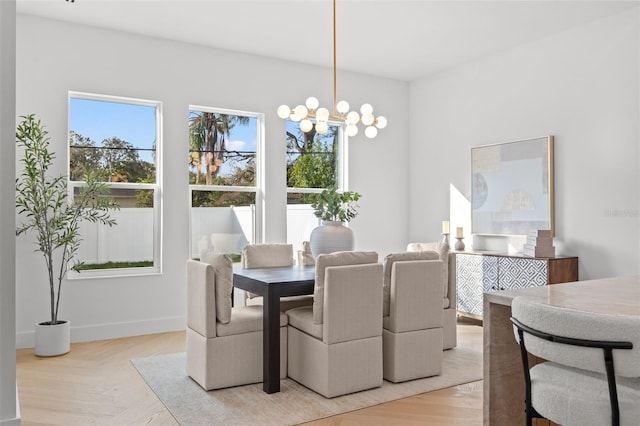 dining space with light parquet flooring and a notable chandelier