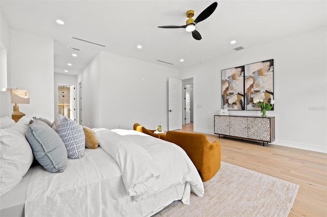 bedroom featuring connected bathroom and light hardwood / wood-style flooring