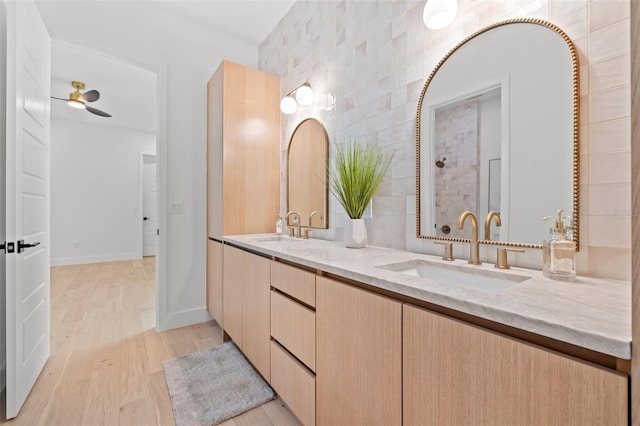 bathroom featuring ceiling fan, vanity, hardwood / wood-style floors, and a shower