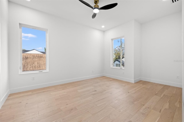 empty room with ceiling fan and light hardwood / wood-style floors