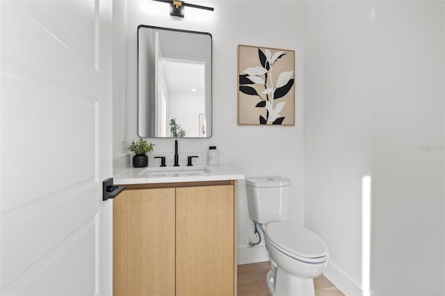 bathroom featuring vanity, hardwood / wood-style floors, and toilet