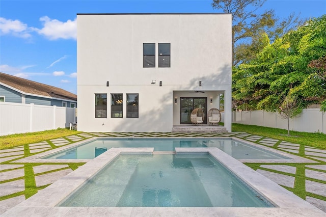 rear view of property featuring ceiling fan, a pool with hot tub, and a patio