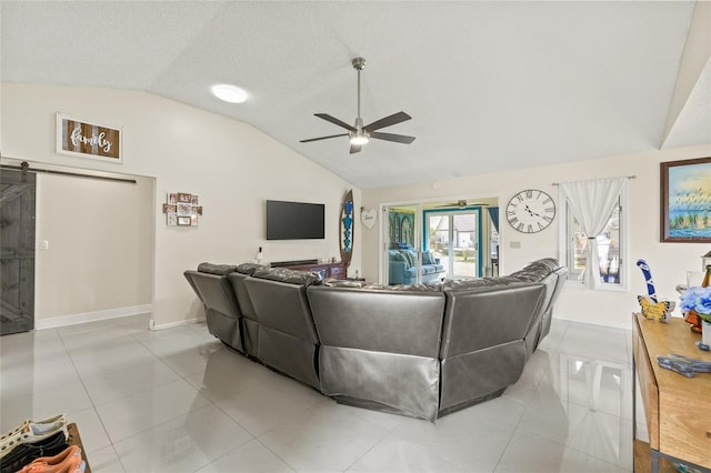 1007 Lake Avoca Dr, Tarpon Springs, FL 34689 - living room with ceiling fan, a textured ceiling, light tile patterned flooring, vaulted ceiling, and a barn door