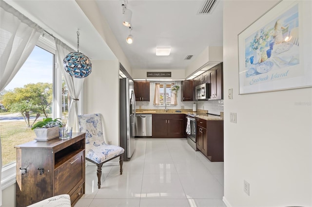 1007 Lake Avoca Dr, Tarpon Springs, FL 34689 - kitchen featuring dark brown cabinetry, sink, tasteful backsplash, light tile patterned floors, and appliances with stainless steel finishes