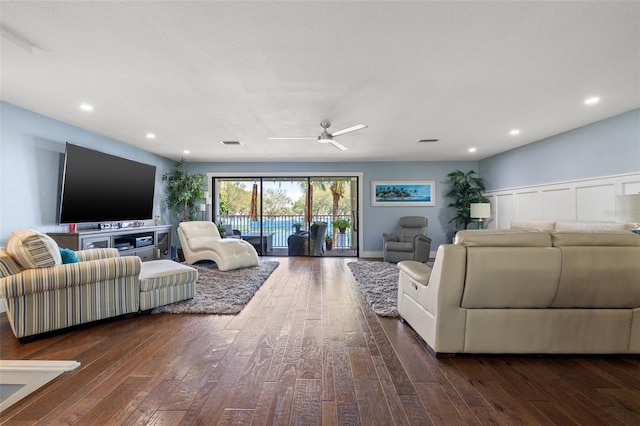 living room with ceiling fan and dark hardwood / wood-style flooring