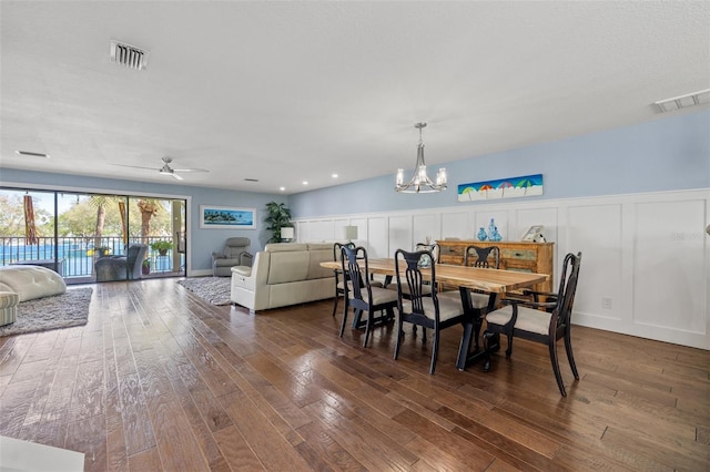 dining room with dark hardwood / wood-style flooring and ceiling fan with notable chandelier