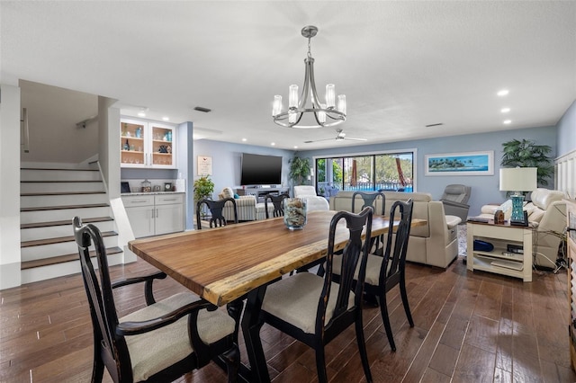 dining area featuring dark hardwood / wood-style floors and ceiling fan with notable chandelier