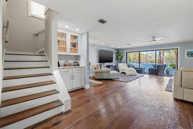 living room featuring ceiling fan and dark hardwood / wood-style flooring