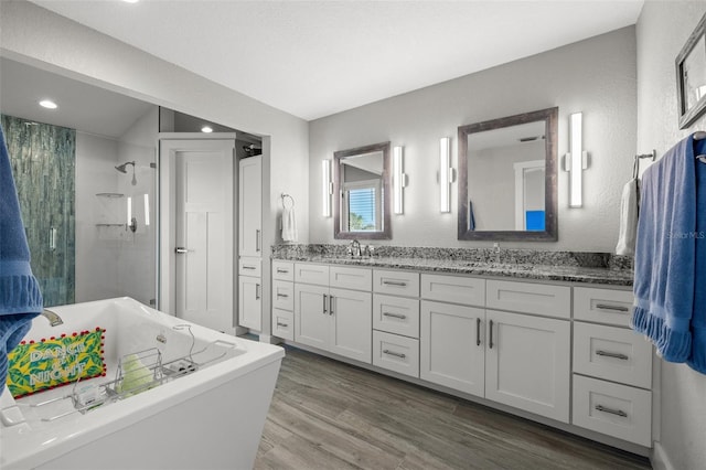 bathroom featuring vanity, hardwood / wood-style flooring, and plus walk in shower