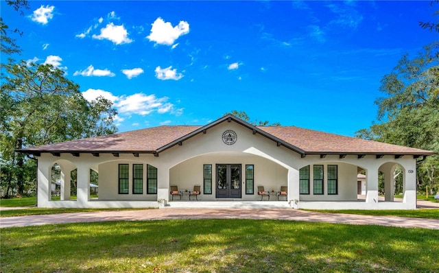 rear view of house with a lawn, french doors, and a patio area