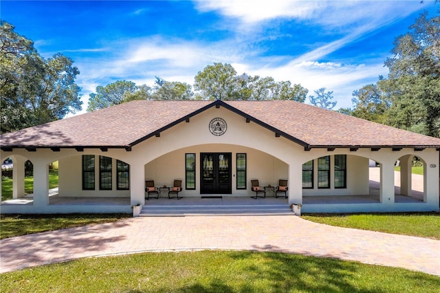 back of property with a patio, a yard, and french doors