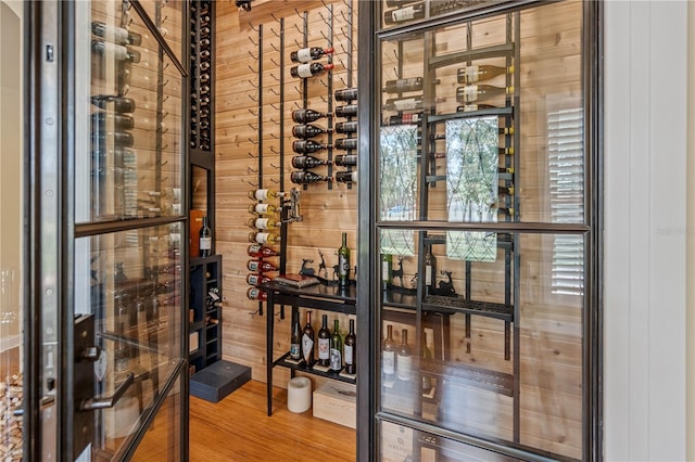 wine room featuring hardwood / wood-style flooring and wood walls