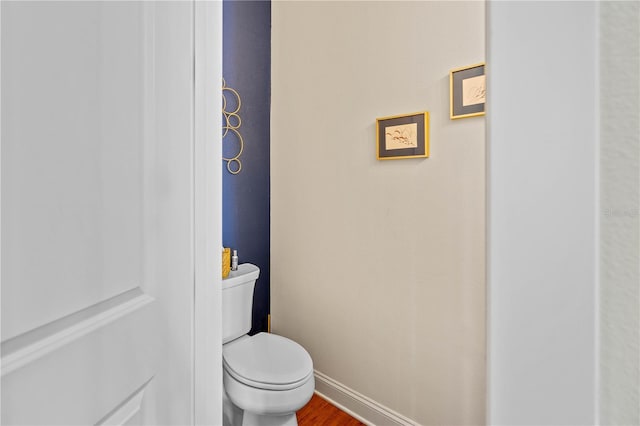 bathroom with hardwood / wood-style flooring and toilet