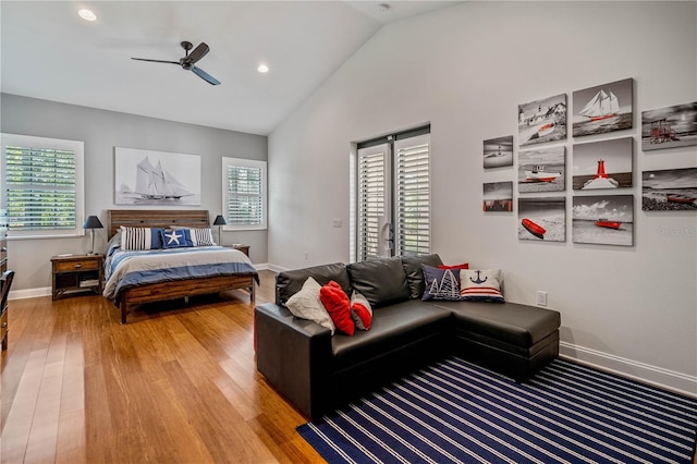 bedroom with multiple windows, hardwood / wood-style flooring, lofted ceiling, and ceiling fan