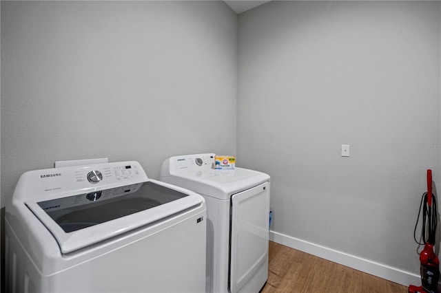 laundry area with wood-type flooring and washer and clothes dryer