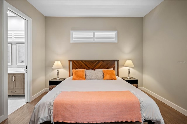 bedroom featuring connected bathroom and hardwood / wood-style floors