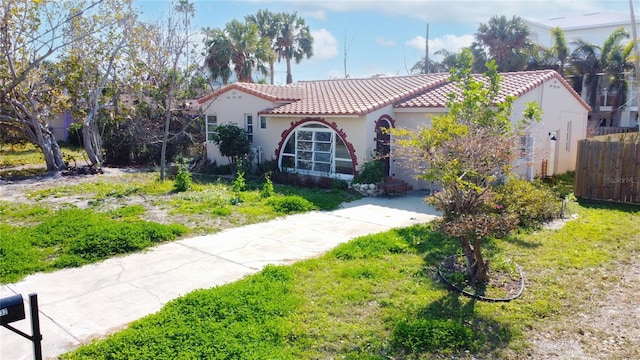 mediterranean / spanish house featuring a front lawn