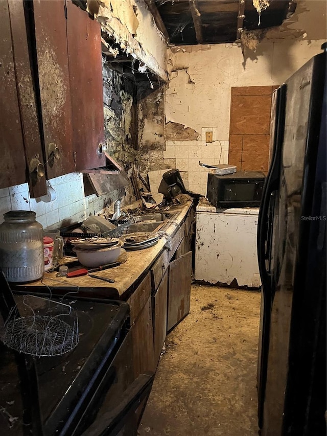 kitchen featuring dark brown cabinets, sink, and black appliances