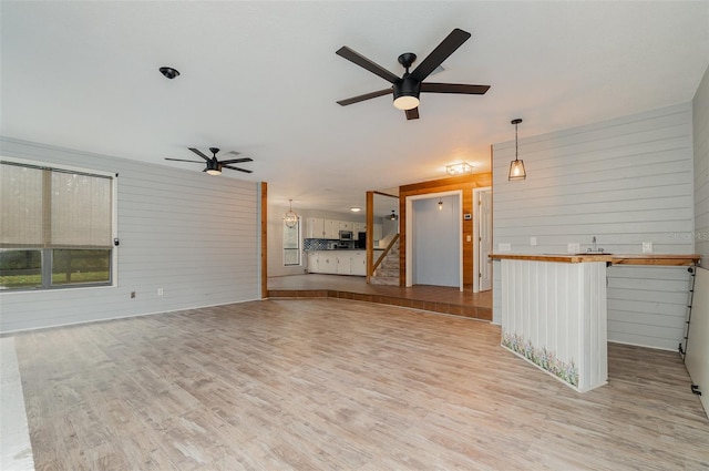 unfurnished living room with ceiling fan and light hardwood / wood-style floors